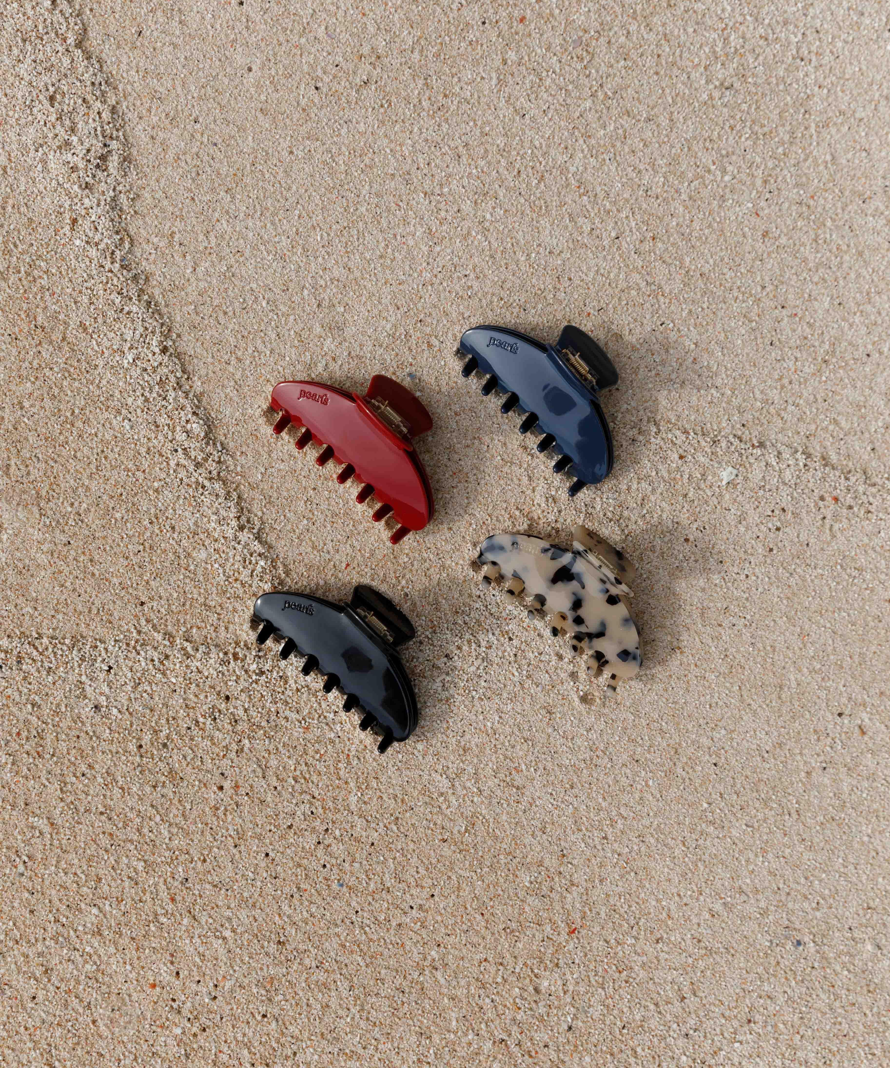 Four Pearls Studios claw clips on the sand